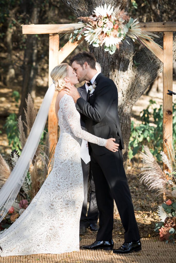 bride and groom kissing at alter