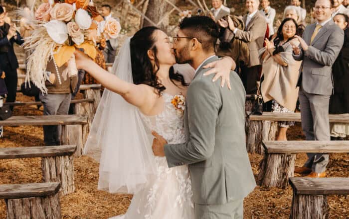 Bride and groom kiss at their wedding ceremony in the hill country